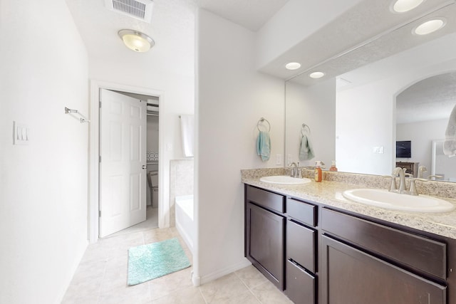 7105 Napoleon Rd NE, Rio Rancho, NM 87144 - full bathroom with tile patterned floors, double vanity, toilet, and baseboards
