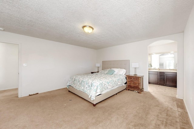 7105 Napoleon Rd NE, Rio Rancho, NM 87144 - bedroom with light carpet, arched walkways, a textured ceiling, and ensuite bathroom