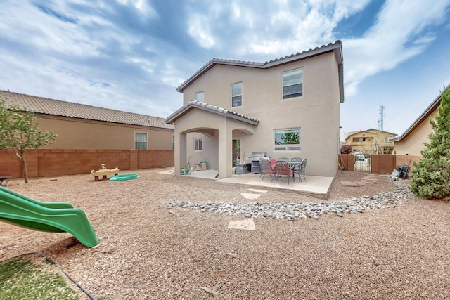 7105 Napoleon Rd NE, Rio Rancho, NM 87144 - back of property featuring stucco siding, fence, a tile roof, a playground, and a patio