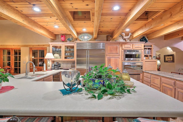 kitchen featuring recessed lighting, beam ceiling, a sink, and stainless steel built in fridge