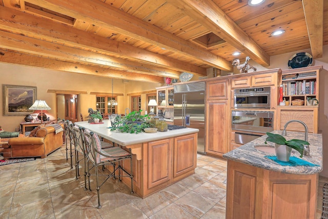 kitchen featuring oven, stainless steel built in refrigerator, beam ceiling, a large island, and wooden ceiling