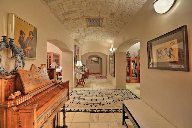 253 Spring Creek Pl NE, Albuquerque, NM 87122 - corridor featuring arched walkways, brick ceiling, lofted ceiling, light tile patterned floors, and baseboards