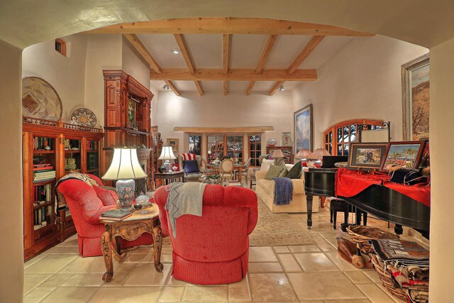 living room with a towering ceiling, coffered ceiling, tile patterned flooring, and beam ceiling