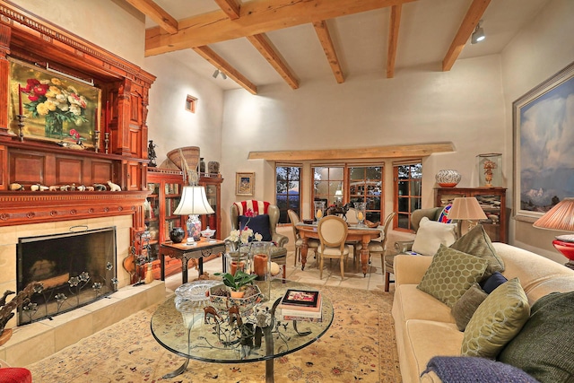 living room featuring beamed ceiling, a tile fireplace, and a high ceiling