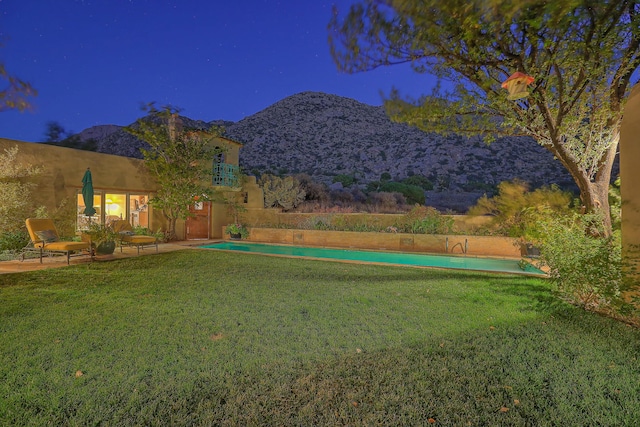 view of yard featuring an outdoor pool, a mountain view, and a patio