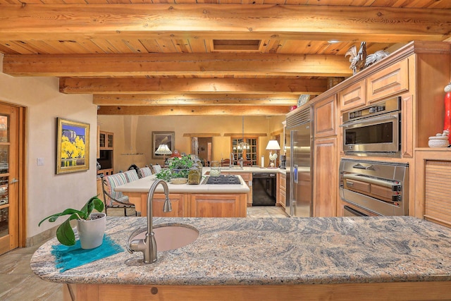 253 Spring Creek Pl NE, Albuquerque, NM 87122 - kitchen featuring appliances with stainless steel finishes, a center island, a sink, wood ceiling with exposed beams, and a chandelier