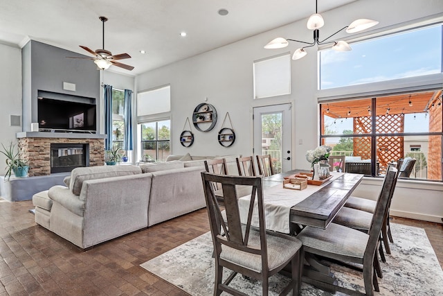 dining space with recessed lighting, ceiling fan with notable chandelier, and a fireplace
