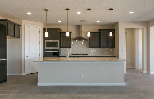 kitchen with a sink, wall chimney exhaust hood, decorative backsplash, dark brown cabinets, and appliances with stainless steel finishes
