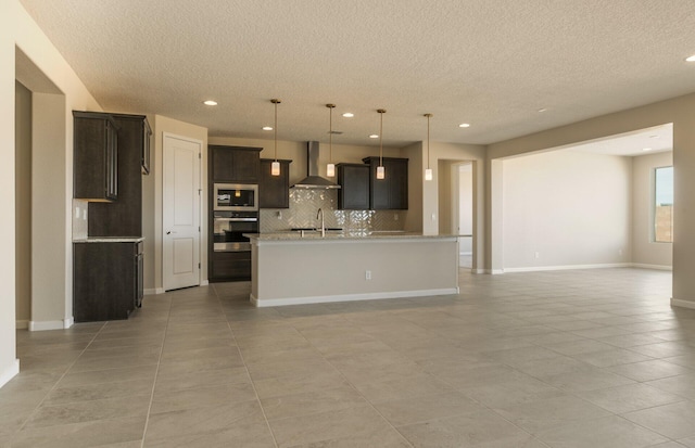 kitchen featuring open floor plan, wall chimney range hood, a textured ceiling, and decorative backsplash