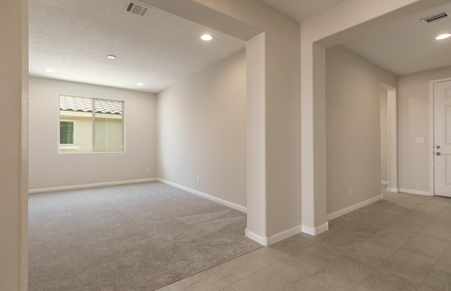 unfurnished room featuring light colored carpet, baseboards, visible vents, and recessed lighting