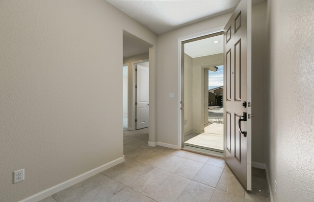 entryway featuring light tile patterned flooring and baseboards