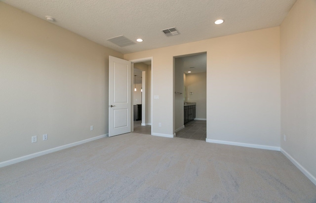 spare room with light carpet, baseboards, visible vents, and recessed lighting