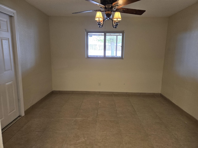 unfurnished room featuring a ceiling fan, baseboards, and tile patterned floors