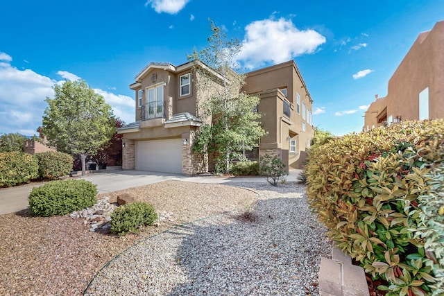 3404 Lockerbie Dr SE, Rio Rancho, NM 87124 - view of front of house with an attached garage, stone siding, stucco siding, and driveway