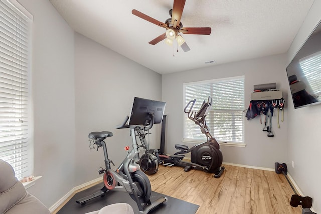 3404 Lockerbie Dr SE, Rio Rancho, NM 87124 - exercise room featuring wood finished floors, visible vents, a ceiling fan, and baseboards