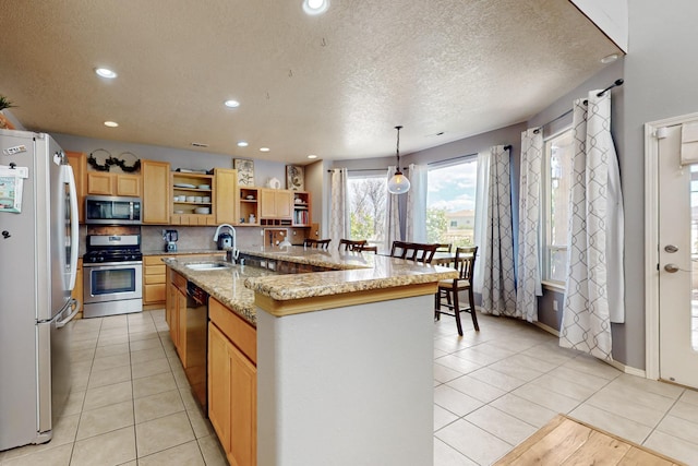 3404 Lockerbie Dr SE, Rio Rancho, NM 87124 - kitchen with a kitchen island with sink, a sink, recessed lighting, open shelves, and appliances with stainless steel finishes