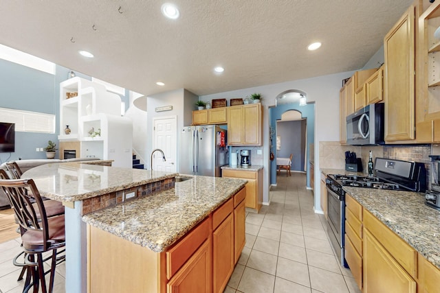 3404 Lockerbie Dr SE, Rio Rancho, NM 87124 - kitchen featuring open shelves, a sink, light tile patterned flooring, a breakfast bar area, and appliances with stainless steel finishes