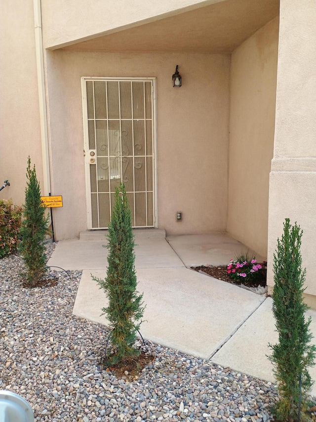 entrance to property featuring stucco siding