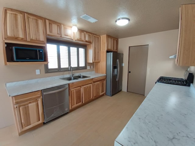 kitchen featuring light countertops, visible vents, stainless steel appliances, and a sink