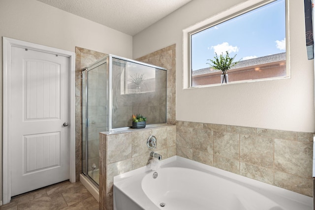 full bath featuring a textured ceiling, a bath, and a stall shower