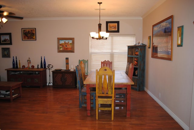 dining space featuring dark wood finished floors, baseboards, visible vents, ceiling fan with notable chandelier, and ornamental molding