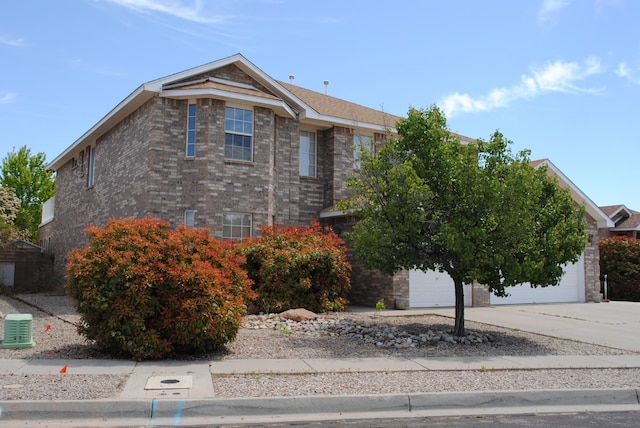 view of front of property featuring a garage, brick siding, and concrete driveway