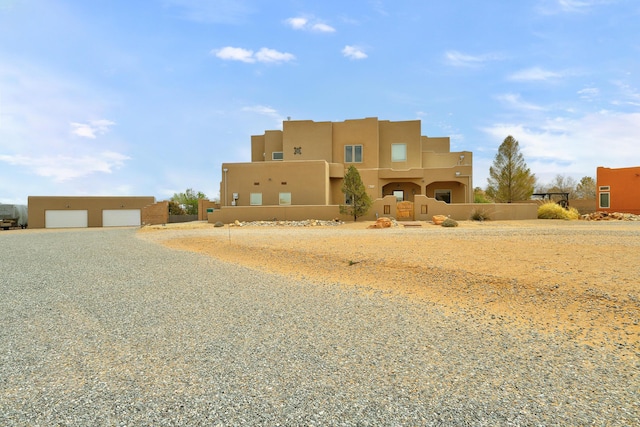 southwest-style home featuring a garage and stucco siding
