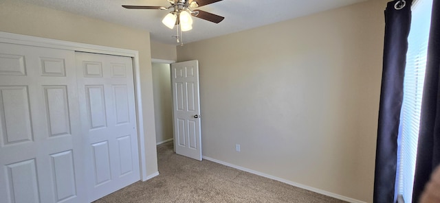 unfurnished bedroom featuring baseboards, a ceiling fan, carpet floors, and a closet