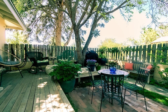 deck with a fenced backyard and a patio