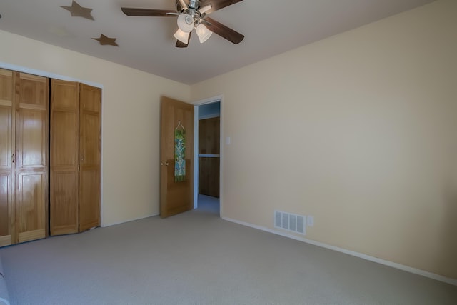 unfurnished bedroom featuring light carpet, a closet, visible vents, and baseboards