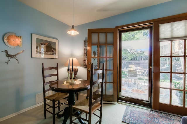 dining room featuring baseboards, vaulted ceiling, visible vents, and carpet