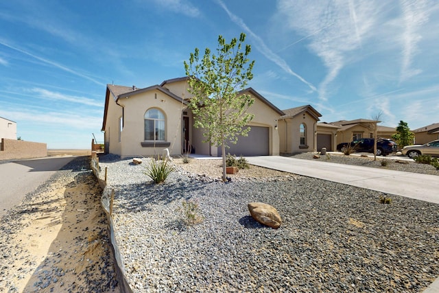 view of front of home with concrete driveway, an attached garage, and stucco siding