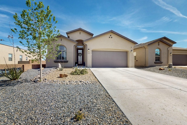 mediterranean / spanish house featuring an attached garage, stucco siding, and driveway