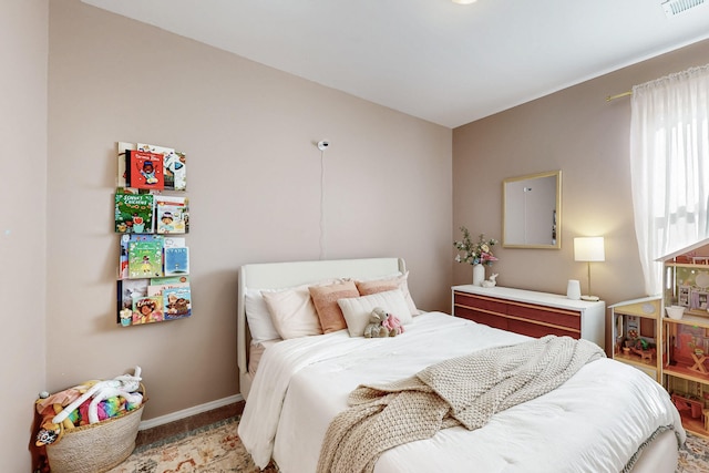 bedroom featuring baseboards and visible vents