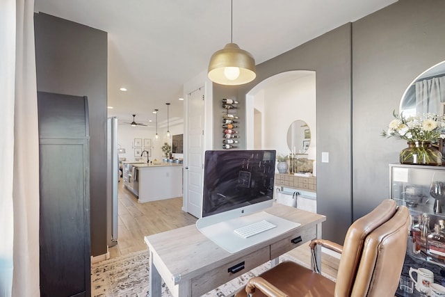 office featuring arched walkways, light wood-style flooring, recessed lighting, and ceiling fan