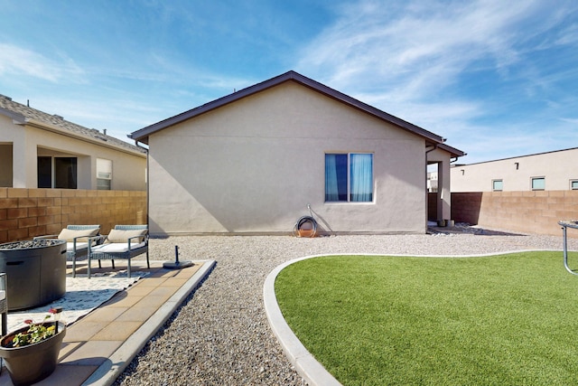 back of property featuring a patio area, a lawn, stucco siding, and fence