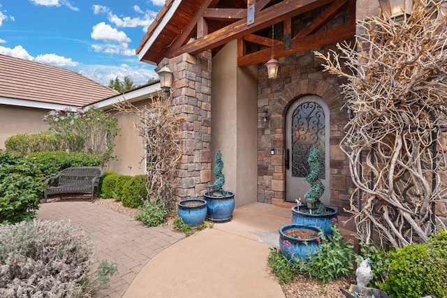 entrance to property with stone siding and stucco siding