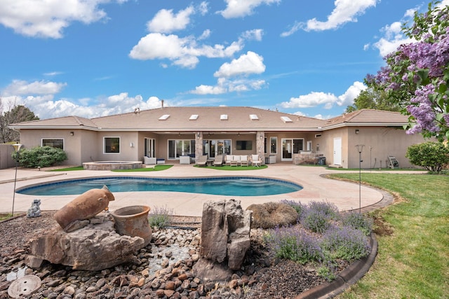 pool with a lawn, an outdoor hangout area, a hot tub, and a patio