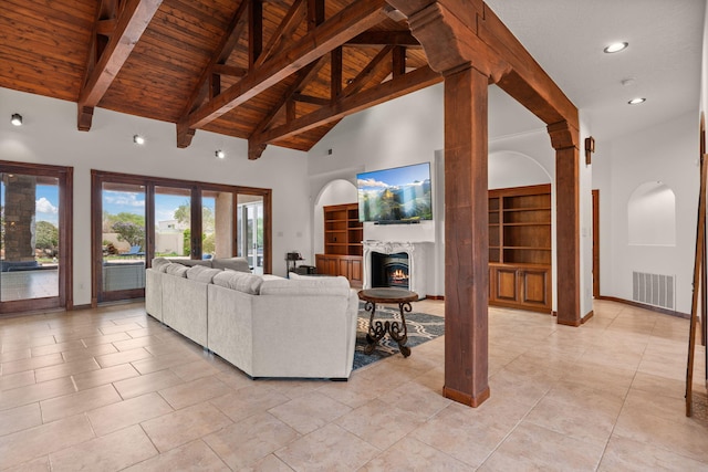 living room with visible vents, beamed ceiling, wood ceiling, high vaulted ceiling, and a lit fireplace
