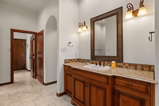 bathroom featuring decorative backsplash, baseboards, vanity, and tile patterned floors
