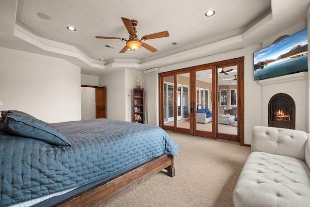 bedroom with carpet, a raised ceiling, visible vents, french doors, and access to outside