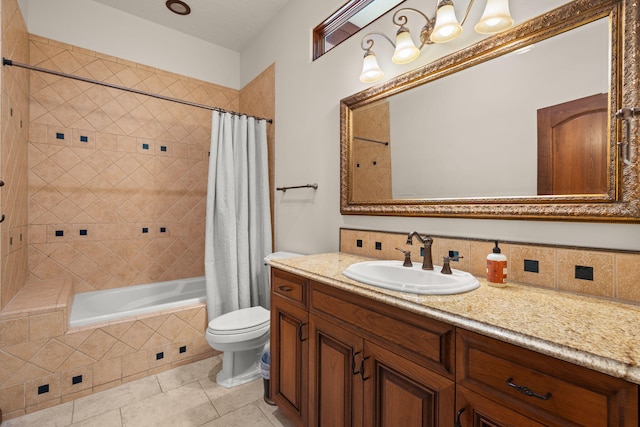 full bath with toilet, vanity, tile patterned floors, and tiled shower / bath