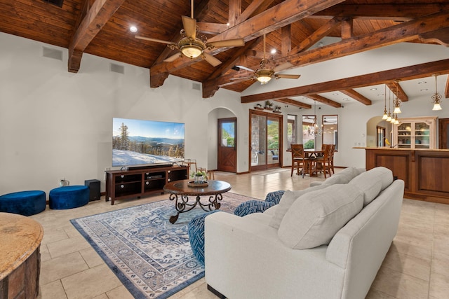 living area featuring a ceiling fan, lofted ceiling with beams, wood ceiling, arched walkways, and visible vents
