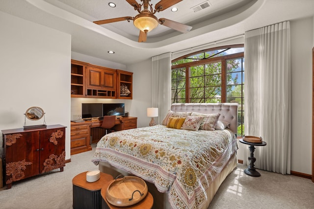 bedroom featuring recessed lighting, built in study area, visible vents, and light colored carpet