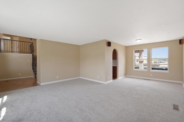 10516 Calle Sombra NW, Albuquerque, NM 87114 - spare room with arched walkways, light carpet, visible vents, and baseboards
