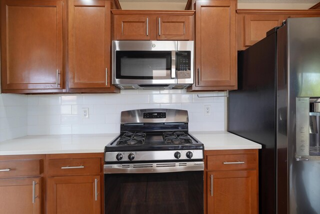 10516 Calle Sombra NW, Albuquerque, NM 87114 - kitchen with light countertops, tasteful backsplash, brown cabinets, and stainless steel appliances