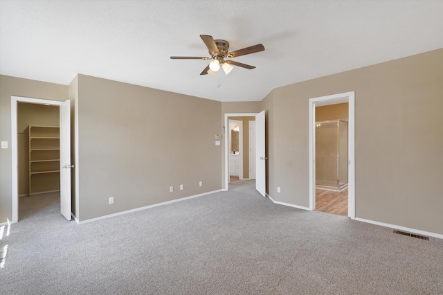 10516 Calle Sombra NW, Albuquerque, NM 87114 - unfurnished bedroom with carpet flooring, baseboards, visible vents, a spacious closet, and ensuite bath