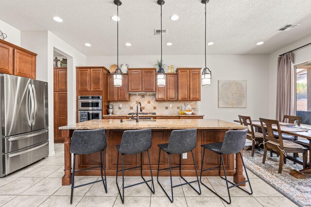 4024 Colina Roja Ln NE, Rio Rancho, NM 87124 - kitchen featuring stainless steel appliances, a textured ceiling, backsplash, brown cabinets, and a sink