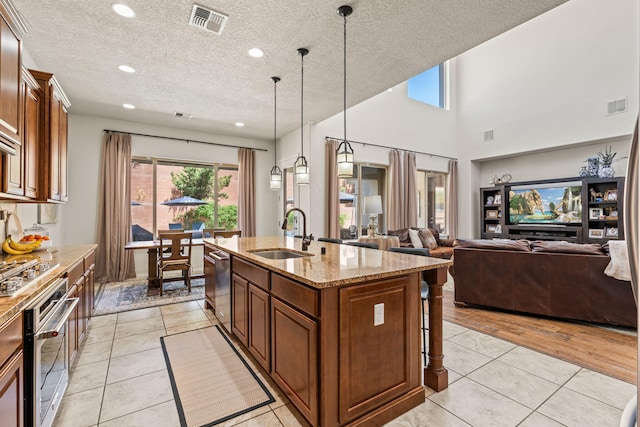 kitchen featuring light tile patterned floors, appliances with stainless steel finishes, visible vents, and a sink