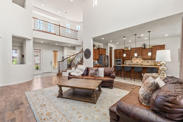 4024 Colina Roja Ln NE, Rio Rancho, NM 87124 - living room with stairway, light wood-type flooring, a high ceiling, and recessed lighting